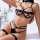 Woman modeling black strappy lingerie set with gold chains, featuring bra, garter belt, and thigh straps for couples.
