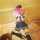 A person wearing a cute sailor school uniform set, including a pink book titled hand job, sits on the floor reading while a d...
