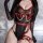 Sexy seamless lingerie bodysuit featuring sheer mesh tank top with red leather straps and pearl accents, perfect for women se...