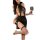 Woman in black sheer bodysuit with skirt, fishnet stockings, holding wine glass – sexy secretary lingerie set.