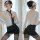 Woman in sexy secretary costume set with sheer blouse, black pencil skirt, tie, and stockings for role play or cosplay.