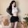 Woman in white crop top, black mini skirt, sheer tights, and long gloves posing with teddy bears and roses.