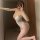 Woman in white lace bodysuit taking mirror selfie.