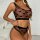 Woman wearing sexy sheer black lingerie set with heart print, featuring mesh bra and matching high-waist panties.