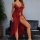 Woman wearing a red sheer lace sleep dress with delicate straps and a flowing silhouette, posing elegantly beside a black sof...