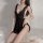 Woman wearing black lace sleepwear with back slit, sheer mesh nightgown for flirty bedroom style.