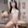 Woman modeling a sheer white lace bodysuit with bunny ears, featuring an open crotch design and thigh-high stockings.