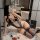 Woman posing in black lace sheer bodysuit with garter stockings, romantic setting with roses and chanel bag.
