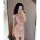 Woman in mirror wearing a sexy shiny pink sequin sleep dress with sheer backless design for nightclub or lingerie.
