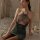 Woman wearing a sexy sparkle halter nightclub bodycon dress, featuring a seductive secretary style with sheer details and a f...