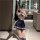 Woman kneeling in bathroom wearing sexy student uniform lingerie set with hot jk style bodysuit and mini skirt.