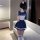 Woman wearing sexy student uniform lingerie set with hot jk style bodysuit and mini skirt, posing indoors.
