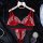 Red lace lingerie set with sheer romantic design, featuring a bra and thong displayed on a hanger with pearls and decorative ...