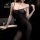 Woman wearing a sexy transparent black bodysuit and stockings set, featuring lace thong design and plus size fit.
