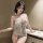 Woman wearing a sexy transparent lace bodysuit with an open-crotch design, posing elegantly beside a countertop with a wine g...