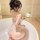 Woman in bathroom wearing sexy transparent lace bodysuit with open-crotch design, showcasing elegant and seductive style.