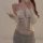 Woman wearing sexy transparent lace bodysuit with open-crotch design, paired with gray sweatpants and white cardigan.