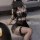 Woman wearing black lace lingerie set with push-up bra, sheer skirt, and fishnet stockings.
