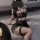 Woman wearing black lace lingerie set with fishnet stockings, featuring no-remove bra and matching outfit for small to plus s...