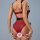 Woman wearing red velvet lace bodysuit with high-waisted shapewear thong, elegant silhouette, black straps and belt detail.