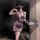 Woman in purple lace cheongsam lingerie with sheer panels, holding a black fan, posing elegantly indoors.
