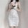 Woman wearing a white vintage lace cheongsam sleep dress with sheer cut-outs and side ties, holding a pink rose.