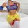 Sheer lace maid costume featuring a transparent top with blue trim, yellow tutu skirt, and red ribbon accents on stockings. p...