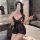 Woman in bathroom wearing black sheer lace sleepwear set with transparent mesh, posing seductively by bathtub.