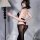 A woman poses elegantly wearing a black bodysuit set featuring a backless cutout design, sheer stockings, and an adjustable c...