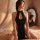 A woman poses elegantly in a black silk-look cheongsam lingerie dress featuring a high slit and halter neck design, perfect f...