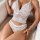 Woman wearing white lace lingerie set with cami top and shorts, elegant sleepwear for women.
