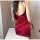 Woman wearing a red silky sleep dress with side cutouts and tie details, showcasing its elegant and alluring design.