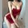 Woman wearing a red silky sleep dress with side lace-up cutouts and tie details, showcasing a sexy and elegant nightwear desi...