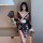 A woman poses elegantly in a black floral japanese-style open-front kimono, holding a fan. the attire features intricate desi...