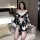 A woman poses in a black and white floral patterned kimono with an open front design, featuring long sleeves and a cinched wa...