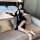 A woman poses on a couch wearing a black lace cheongsam, featuring a backless design and high slit, perfect for retro role pl...