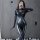 Woman in black spider-man bodysuit with web pattern, taking selfie; sexy tight-fit open-crotch design for adults.