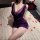 Woman in purple lace bodycon skirt from starry night dance lingerie set, posed on bed with rose petals.