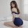 A woman poses on a bed wearing a navy blue and white su shi restrained female police instructor uniform set, featuring a tigh...