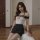 A woman models a stylish uniform set featuring a white top with black straps and a black skirt, designed for a seductive look...