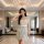 Woman wearing su shi sexy deep v floral lingerie dress - sheer mesh seductive nightwear in elegant room with chandelier.