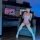 A woman poses in a gaming setup wearing a playful pink lingerie set with sheer stockings, embodying a sensual cosplay vibe.