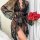 Woman wearing sheer black polka dot lace sleepwear set with matching robe, bra and panty, holding red roses.