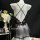 Black sheer lace bodysuit with crisscross straps and bow detail, featuring a low-cut bust and seductive cut-outs for summer.