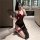 Woman in black sheer cheongsam lingerie with red trim, high slit, and lace garters, posing with a fan in a modern bathroom.