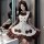 A woman poses in a maid lolita outfit, featuring a cream and brown dress with ruffles, bows, and buttons, perfect for anime-t...