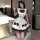 A woman poses in a maid lolita outfit, featuring a cream dress with brown accents, bows, and ruffles, perfect for anime-theme...