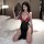 Woman in suoqing floral rose lingerie dress with deep v and high slit, holding lace fan on bed.