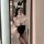 Woman in suoqing sexy catgirl maid costume taking mirror selfie, featuring lace bodice, bunny ears, and thigh-high stockings.