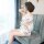 A woman sits on a couch wearing a floral-patterned sheer robe, showcasing an elegant and feminine design perfect for intimate...